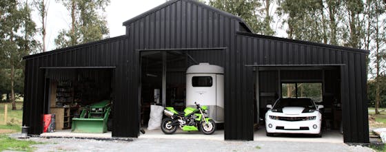 Wide Span Sheds exterior view of a shed containing horse float, motorbike and other vehicles