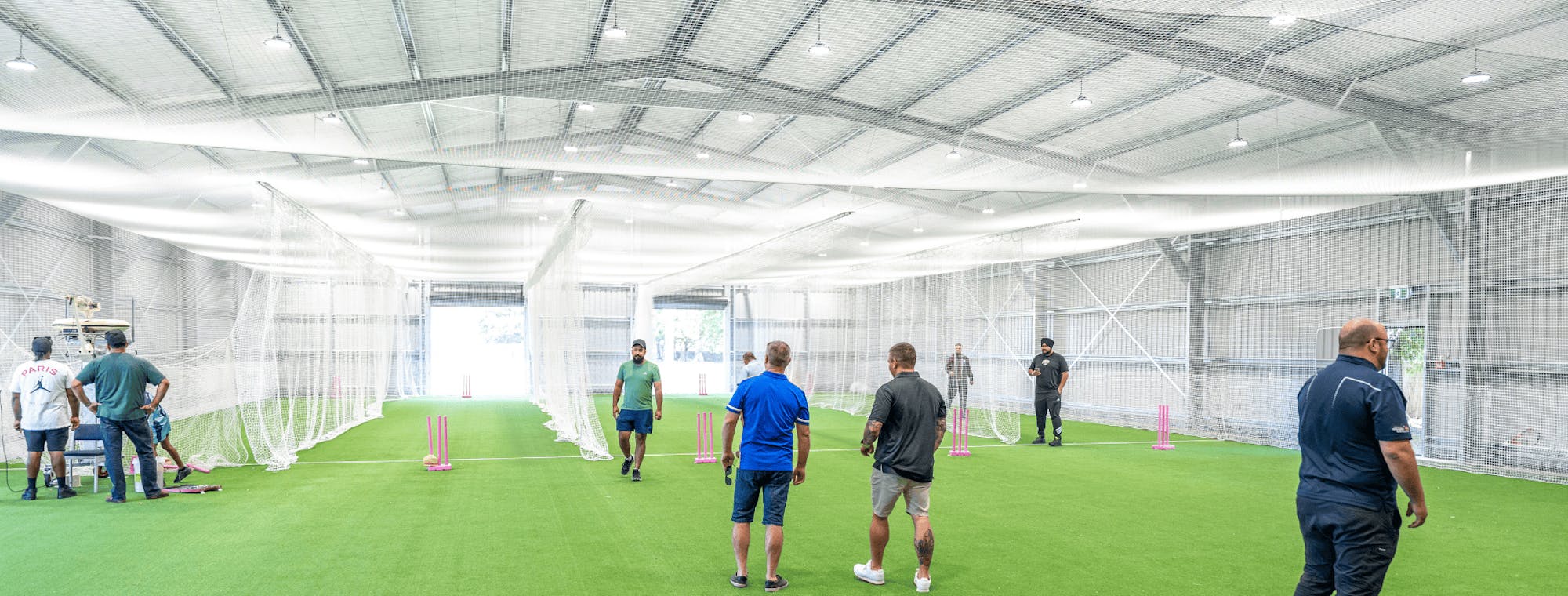 Cricket club community shed design with players practicing