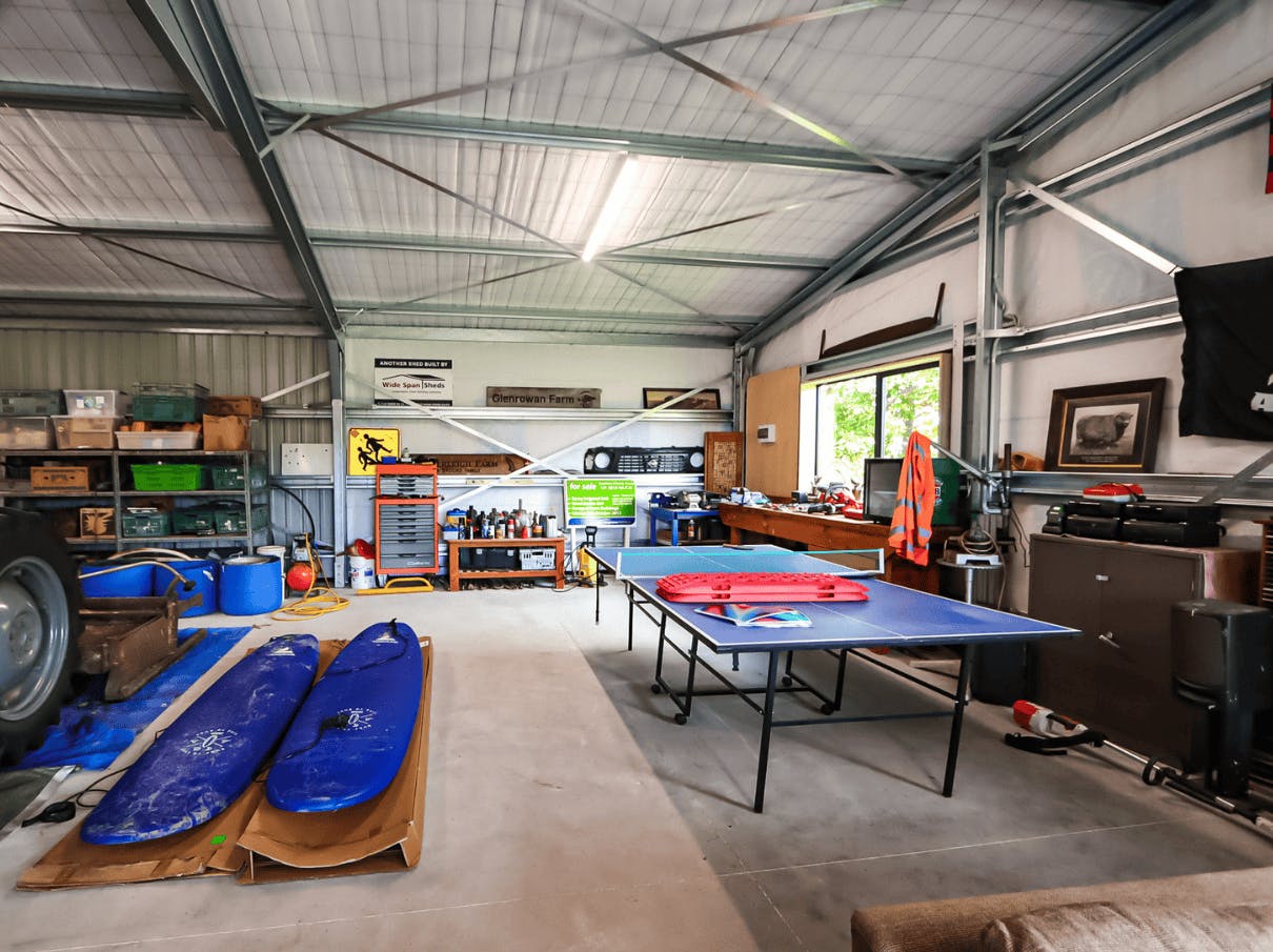 Man cave with poll table and paddle boards - Wide Span Sheds